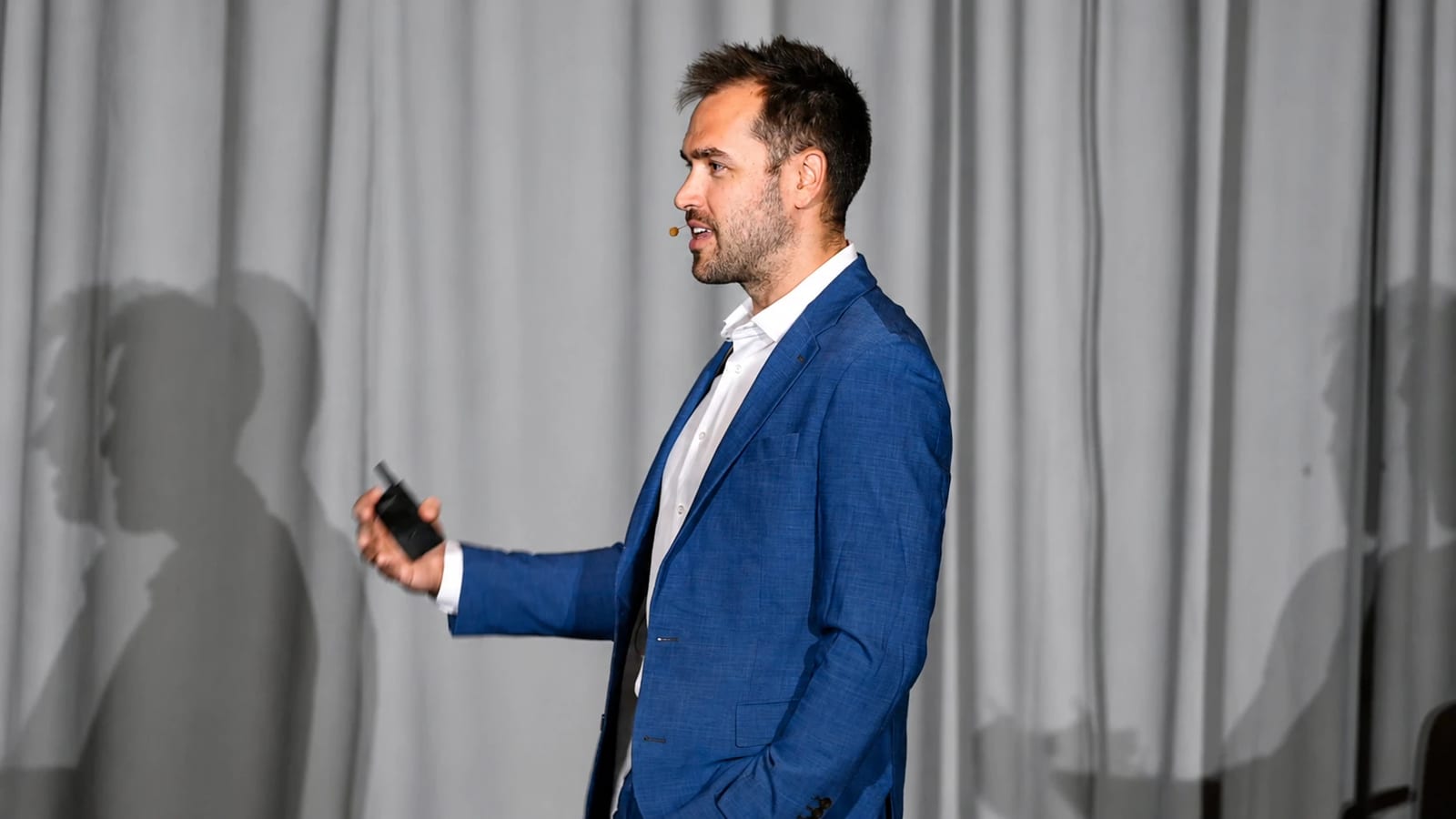 Nick Fischer presenting to chiropractors with a slide clicker in hand.
