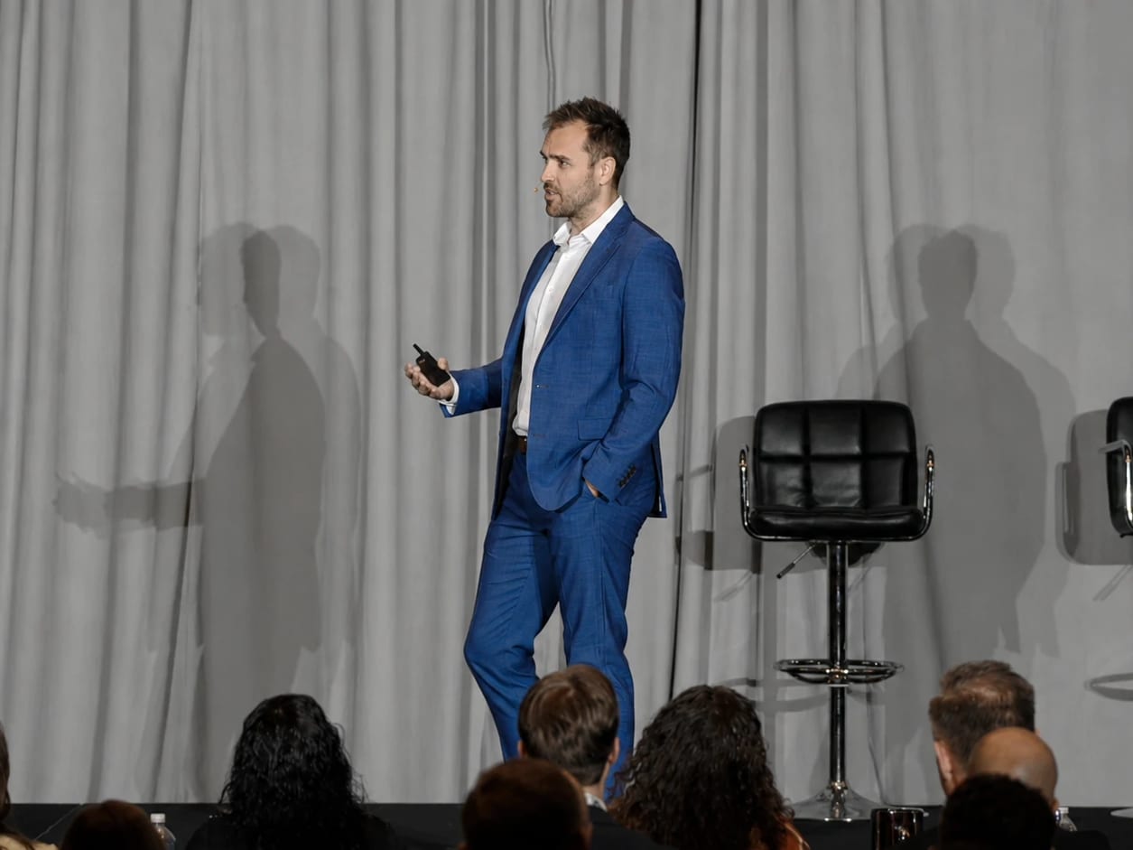 Nick Fischer walking the stage during a chiropractic marketing talk.